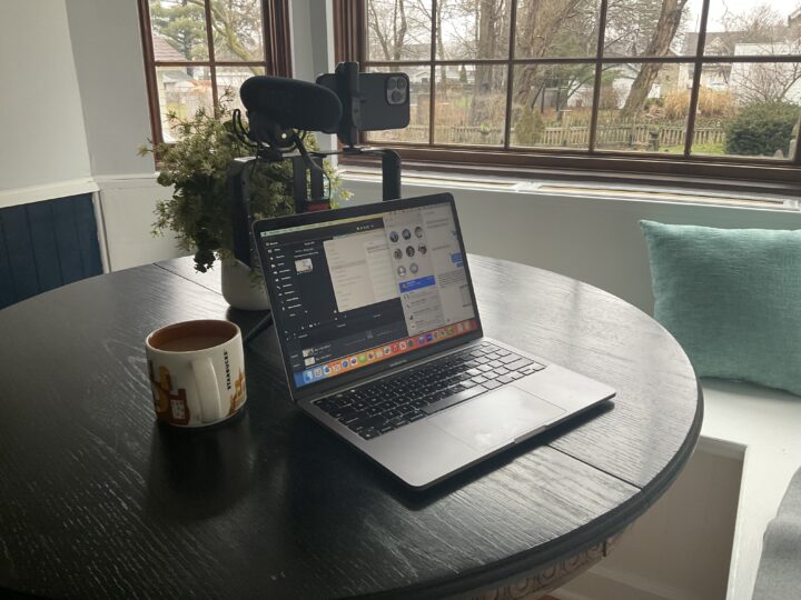 MacBook Pro with external camera and microphone on a table for recording class lectures